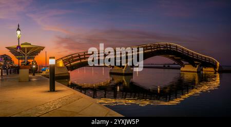 Ponte illuminato e viali sul lungomare nel resort di Lefkada sull'isola di Lefkada Foto Stock