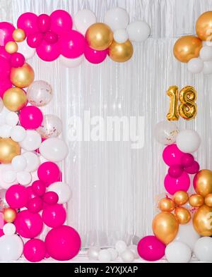 Palloncini colorati e luminosi per un compleanno di diciotto anni. Uno striscione natalizio con il numero 18. Il diciottesimo anniversario. Foto Stock