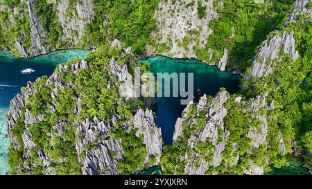 Una vista aerea mozzafiato di una tranquilla laguna tropicale circondata da spettacolari scogliere calcaree coperte da lussureggiante vegetazione. Il wat color smeraldo cristallino Foto Stock