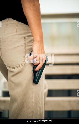 DONNA CON UNA PISTOLA, VISTA POSTERIORE Foto Stock