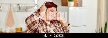 Inoltre, le grandi donne ballano allegramente con la musica mentre preparano il cibo in una luminosa zona cucina Foto Stock