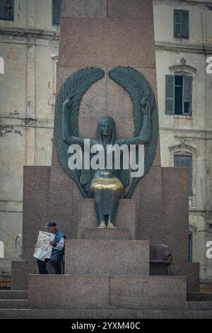 Il monumento Saad Zaghloul Pasha ad Alessandria, in Egitto, presenta una statua femminile alata alla sua base, con antichi edifici coloniali come sfondo. Foto Stock
