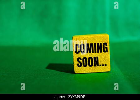 Messaggio in arrivo scritto su un cubo di legno giallo con sfondo verde. Simbolo concettuale in arrivo. Copia spazio. Foto Stock