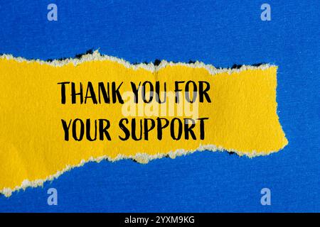 Grazie per il messaggio di supporto scritto su un pezzo di carta giallo strappato con sfondo blu. Grazie concettuale per il vostro simbolo di supporto. Copia Foto Stock