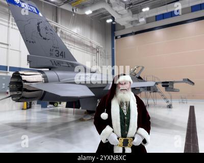 Babbo Natale posa per una foto con un F-16 Fighting Falcon assegnato al 148th Fighter Wing, Minnesota Air National Guard, il 13 dicembre 2024. Babbo Natale Foto Stock