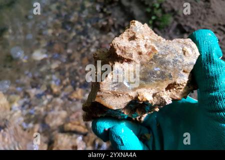 Frammenti di Chalcedony colorati con impurità estratte dall'argilla vicino al fiume, caccia alla roccia. Russia Foto Stock