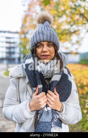 Ritratto verticale di una donna di bellezza con abiti caldi in un parco in autunno Foto Stock