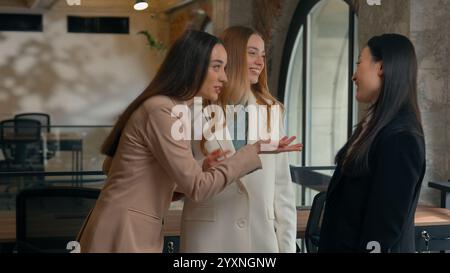 Tre diverse donne d'affari amichevoli sorridenti ridendo ragazze felici donne d'affari multirazziali multietniche colleghi asiatici coreani caucasici co Foto Stock