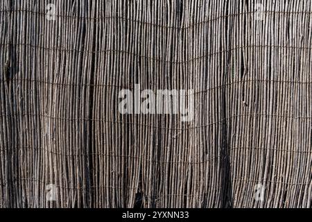 Un primo piano di una recinzione di legno di colore marrone. La recinzione è realizzata in legno e ha una consistenza ruvida. L'immagine ha un aspetto rustico e naturale Foto Stock