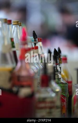 Una fila di bottiglie di liquore con un tappo rosso sulla parte superiore. Le bottiglie sono allineate l'una accanto all'altra Foto Stock