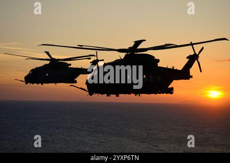 Elicotteri HH-101A dell'Aeronautica militare italiana che volano al tramonto. Foto Stock