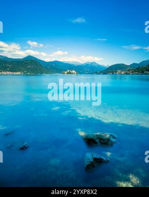 Il paesaggio del lago d'Orta. Rocks and Julius Island, Isola San Giulio in italiano, sullo sfondo. Fotografia a lunga esposizione. Provincia di Novara. Piemonte Foto Stock
