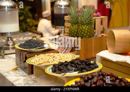 Un vivace buffet con un assortimento di frutta secca datteri, noci e ananas fresco, elegantemente allestito e invitante ad assaporare Foto Stock