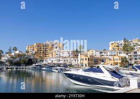 Foto della splendida Marina di navigazione situata a Puerto de Cabopino a Marbella Málaga che mostra le barche in acqua lungo i negozi laterali scattati nel mese Foto Stock