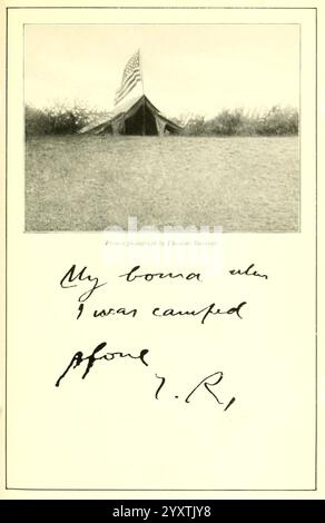 Sentieri per la caccia africana, 1910, caccia, Uganda, descrizione e viaggio, Africa East, Una tenda militare si trova in primo piano su un paesaggio erboso, con una bandiera americana che sventola in primo piano. La scena trasmette un senso di solitudine e di scopo. Sotto l'immagine, una nota scritta a mano recita: "La mia baracca quando ero accampata prima", firmata con iniziali che suggeriscono un legame personale con il luogo e il tempo. Questa giustapposizione di immagini e testo evoca un sentimento di nostalgia e storia, suggerendo le esperienze e i ricordi legati alla vita militare. Foto Stock