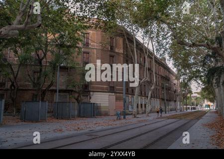 Barcellona, Catalogna, Spagna - 08 04 2023: Serata estiva in via Carrer de Wellington a Barcellona, con binari del tram che vanno accanto ai vecchi bui a quattro piani Foto Stock