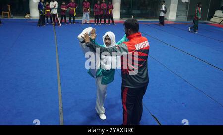 Dacca. 18 dicembre 2024. Una giocatrice di Wushu pratica sotto la guida in uno stadio al coperto nel distretto di Cox's Bazar, Bangladesh, 19 novembre 2024. Negli ultimi anni, il cinese Wushu è diventato uno degli sport popolari del Bangladesh, specialmente nel distretto di Cox's Bazar, che è emerso come un centro di giocatori nazionali Wushu. PER ANDARE CON "Feature: Il Bangladesh's Cox's Bazar diventa hub emergente per Wushu" credito: Xinhua/Alamy Live News Foto Stock