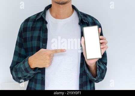 Corpo a metà corta giovane adulto con flanella e camicia bianca che punta al telefono con sfondo bianco isolato Foto Stock
