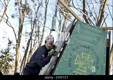 Non esclusiva: LEOPOLI, UCRAINA - 14 DICEMBRE 2024 - Un concorrente sale un ostacolo durante la Quinta corsa Kordon nel Parco Bohdan Khmelnytskyi di cUL Foto Stock