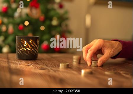 Primo piano di monete IN EURO con sullo sfondo l'albero di Natale Foto Stock