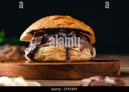 hamburger con gelato al cioccolato. Sandwich con gelato su sfondo in legno. Foto Stock