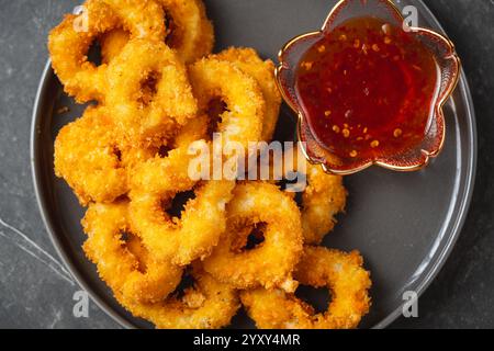 Anelli di calamaro fritti in profondità impanati con salsa tailandese Foto Stock