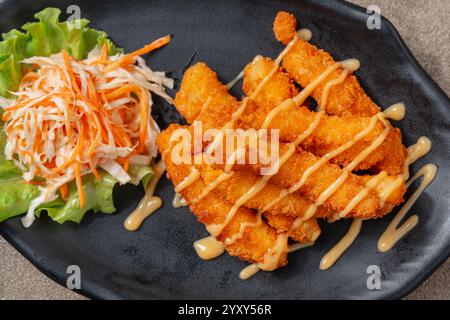 Bastoncini di pesce o bastoncini di pesce fatti di un pesce bianco come il merluzzo che viene impantanato e impanato. Vengono spesso mangiati con salsa tartara, salsa cocktail o ketch Foto Stock