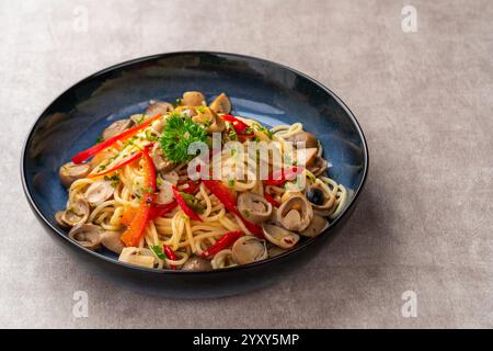 Gli spaghetti aglio e olio sono un tradizionale piatto di pasta italiana di Napoli. Ricetta per la classica pasta aglio e olio con aglio fritto, funghi, paprika, pa Foto Stock