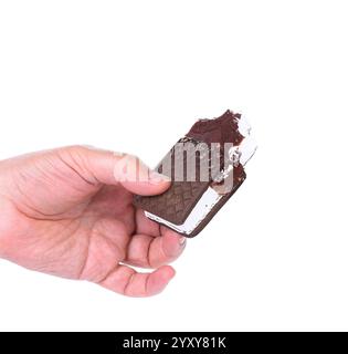 La mano tiene il gelato al cioccolato morso isolato su sfondo bianco Foto Stock