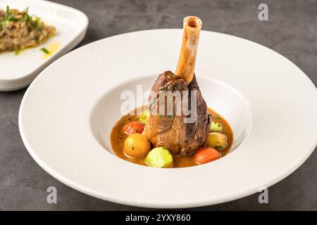 Tradizionale articolazione di agnello brasato a cottura lenta o gambo di agnello con salse Foto Stock