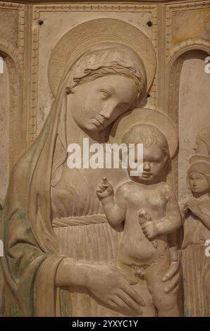 Urbino, Italia - 12 settembre 2024: Madonna con bambino e quattro angeli di Michele di Giovanni da Fiesole nel Palazzo Ducale di Urbino, Italia. Pietra con Foto Stock