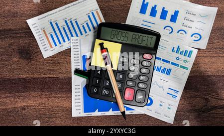 Concetto di profitto lordo scrivere sulla calcolatrice isolata su una tavola di legno. Foto Stock