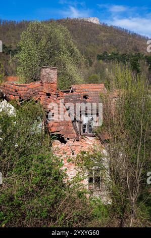 Vecchia casa in rovina nella regione mineraria abbandonata, case devastate in montagna e splendida natura in primavera Foto Stock
