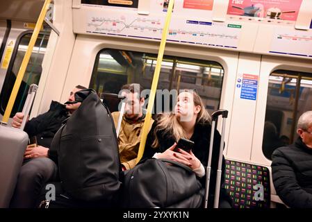 i viaggiatori viaggiano su una linea circolare della metropolitana a londra, inghilterra, con valigie e telefoni Foto Stock