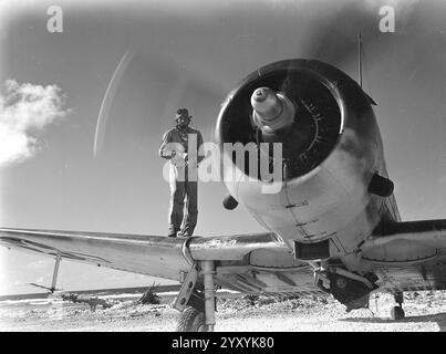 Il capitano John F. Adams, USMC, dello squadrone di ricognitori di bombardieri subacquei degli Stati Uniti VMSB-231 si trova sull'ala del suo aereo Douglas SBD-5 Dauntless a Dalop Island, Atollo Majuro, Isole Marshall, nell'agosto 1944 Foto Stock