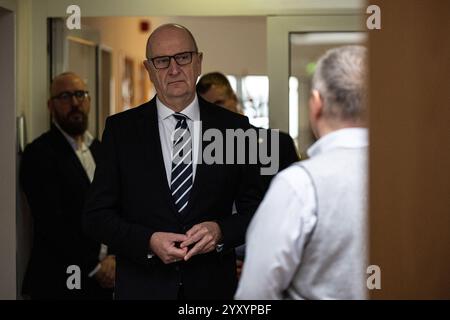 18 dicembre 2024, Brandeburgo, Brandeburgo/Havel: Il Ministro Presidente del Brandeburgo Dietmar Woidke (SPD, M) parla con Sven Rohde, Presidente/CEO del gruppo Jedermann, a Hospiz Brandenburg. Foto: Hannes P. Albert/dpa Foto Stock