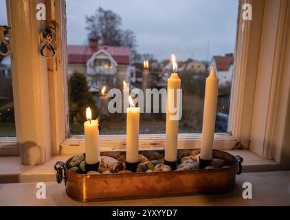 Candelabro tradizionale dell'Avvento con tre candele che bruciano sul terzo Avvento Foto Stock