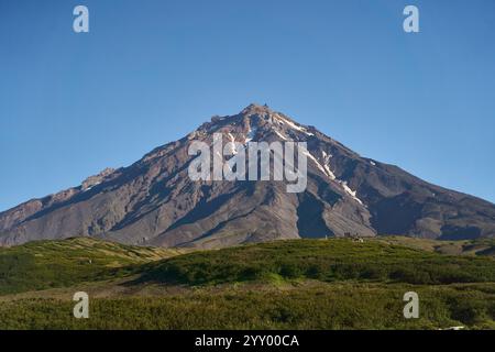 Vulcano Koryaksky. Il maestoso e stupefacente vulcano si trova sotto un chiaro e brillante cielo blu Foto Stock
