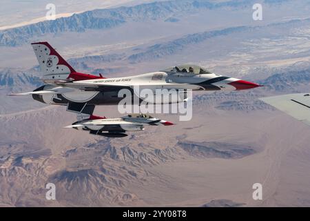 Due F-16 Fighting Falcons assegnati allo United States Air Force Air Demonstration Squadron "Thunderbirds" volano dall'ala sinistra di un KC-135 Stratot Foto Stock