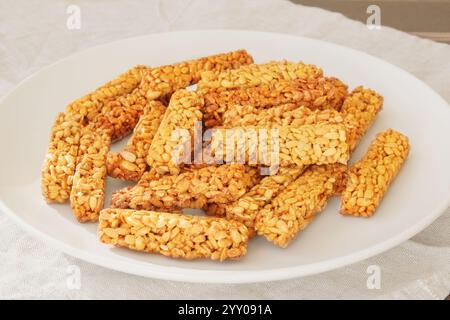 Gozinaki in un piatto di ceramica. Granola dolce in piatto beige per le vacanze. Caramelle vegetariane di semi di girasole. Foto Stock