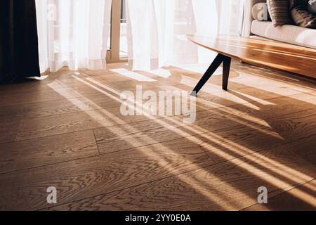 Interni moderni con finestra aperta in stile minimalista. Tulle trasparente con raggi del sole mattutino su sfondo ombroso. Foto di alta qualità Foto Stock