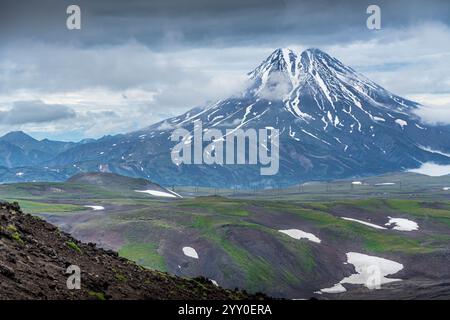 La splendida vista del vulcano Vilyuchik, la foto aerea, con la natura della Kamchatka e le montagne innevate in Russia, Estremo Oriente. Foto Stock