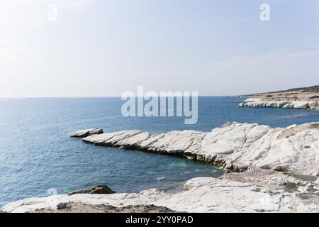 Vista della costa e della grande roccia bianca di gesso presso la spiaggia del Governatore di Limassol, Cipro. Ripide scogliere di pietra e mare blu profondo. Foto Stock