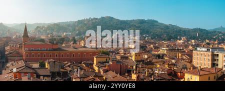 Vista panoramica aerea della città vecchia di Bologna, dell'Emilia Romagna, Italia con tetti di tegole rosse, torre della chiesa, architettura medievale e verdi colline Foto Stock