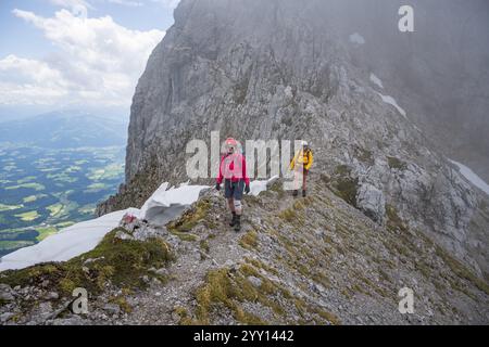 Due alpinisti con caschi in montagna nella nebbia, Wilder Kaiser, Monti Kaiser, Tirolo, Austria, Europa Foto Stock