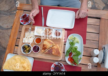 Colazione tradizionale turca con pane fresco, olive, formaggio, pomodori, cetrioli, e varietà di inceppamenti e spalmazioni. Godibile in un ambiente vivace Foto Stock