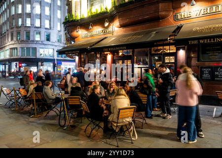 Un gruppo di giovani donne sedute fuori dal Wellington Pub Drinking, Londra, Regno Unito. Foto Stock