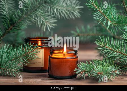 Candele profumate e brasature di abete. Candela Birning con pino, accogliente modello invernale, massaggio hygge e aroma spa. Foto Stock