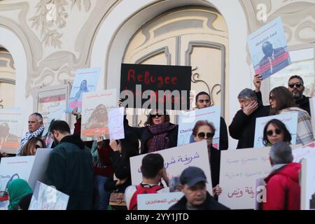 Tunisi, Tunisia, 18 dicembre 2024. Attivisti e manifestanti si riuniscono fuori dal teatro in viale Habib Bourguiba chiedendo diritti per i migranti che intraprendono il pericoloso attraversamento del Mediterraneo per raggiungere l'Italia e l'Europa. I partecipanti hanno denunciato il trattamento dell'Italia nei confronti dei migranti irregolari che raggiungono le sue coste, gli accordi della Tunisia con l'Italia e l'UE per arginare il flusso di arrivi irregolari in Europa e il "nuovo Patto sull'immigrazione e l'asilo” dell'UE. La manifestazione ha coinciso con la giornata internazionale dei migranti Foto Stock