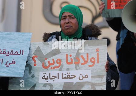 Tunisi, Tunisia, 18 dicembre 2024. Attivisti e manifestanti si riuniscono fuori dal teatro in viale Habib Bourguiba chiedendo diritti per i migranti che intraprendono il pericoloso attraversamento del Mediterraneo per raggiungere l'Italia e l'Europa. I partecipanti hanno denunciato il trattamento dell'Italia nei confronti dei migranti irregolari che raggiungono le sue coste, gli accordi della Tunisia con l'Italia e l'UE per arginare il flusso di arrivi irregolari in Europa e il "nuovo Patto sull'immigrazione e l'asilo” dell'UE. La manifestazione ha coinciso con la giornata internazionale dei migranti Foto Stock